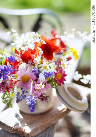 ベンチに春の花のアレンジメント 139570006