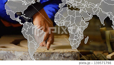 Carving hand working on clay slab with pits at bench, blue-jacket black-cuff, chisel, map-overlay Carving hand working on clay slab with pits at bench, blue-jacket black-cuff, chisel, map-overlay 139571798