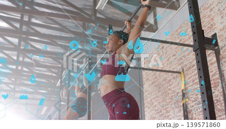Pulling foreground woman lifting chin above bar at warehouse gym rig, with burgundy sportswear, HUD 139571860