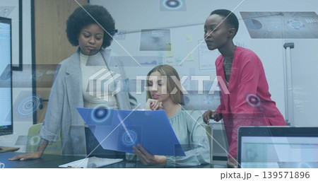 Reviewing three women in grey and red blazers with green blouse at office holding blue-folder Reviewing three women in grey and red blazers with green blouse at office holding blue-folder 139571896