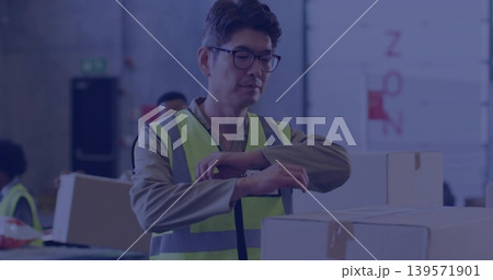 Inspecting mature Korean worker with glasses work shirt safety vest, handling boxes in loading bay Inspecting mature Korean worker with glasses work shirt safety vest, handling boxes in loading bay 139571901