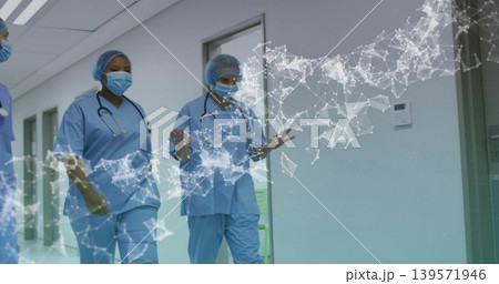 Walking three nurses wearing blue scrubs, masks and stethoscopes down hospital corridor, AR overlay Walking three nurses wearing blue scrubs, masks and stethoscopes down hospital corridor, AR overlay 139571946