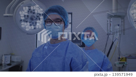 Standing surgical team preparing in operating room, wearing gowns, caps, masks, eyeglasses Standing surgical team preparing in operating room, wearing gowns, caps, masks, eyeglasses 139571949