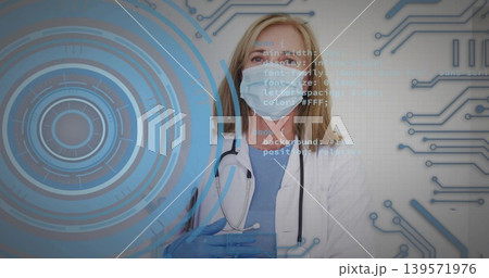 Standing clinician wearing lab coat in clinic, holding blue gloves, surgical mask, stethoscope, HUD 139571976