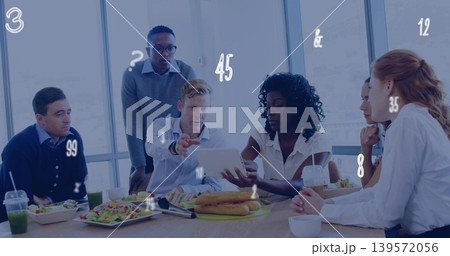 Reviewing work team wearing business attire leaning toward tablet in conference room, with takeout 139572056