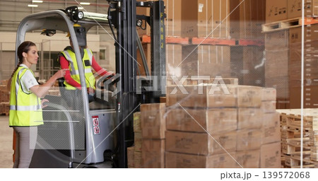 Operating forklift, women directing pallets in warehouse, with hi-vis vests, hard hat, copy space Operating forklift, women directing pallets in warehouse, with hi-vis vests, hard hat, copy space 139572068