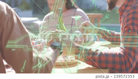 Gathering four adults sharing pizza and wine at backyard wooden table, red plaid, green AR overlay 139572353