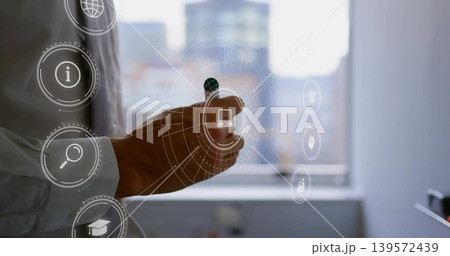 Pointing mid-adult man's right hand interacting with HUD at office window, with stylus, white cuff Pointing mid-adult man's right hand interacting with HUD at office window, with stylus, white cuff 139572439