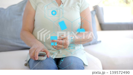 Adult woman testing finger and checking glucose with meter in living room, green top, jeans, icons 139572490
