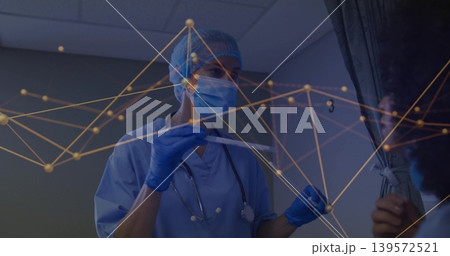 Showing nurse in blue scrubs mask gloves cap holding swab in exam room, stethoscope node graphic 139572521