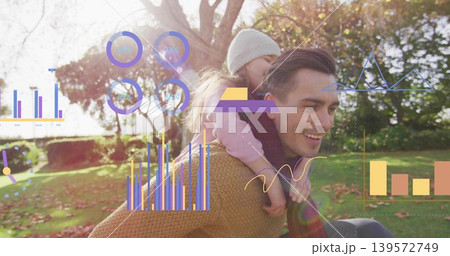 Carrying child, man wearing brown sweater, scarf at park with knit hat, bar charts, copy space 139572749