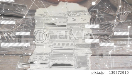 Studying hands in knit sleeves holding torn document with stamp on wood tabletop, digital overlay Studying hands in knit sleeves holding torn document with stamp on wood tabletop, digital overlay 139572910