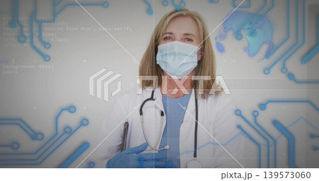 Standing doctor wearing mask blue gloves, coat over scrubs, stethoscope hanging with HUD in clinic Standing doctor wearing mask blue gloves, coat over scrubs, stethoscope hanging with HUD in clinic 139573060