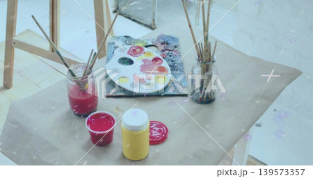 Displaying artist's oval paint palette on kraft paper table, showing jars of brushes and paint pots Displaying artist's oval paint palette on kraft paper table, showing jars of brushes and paint pots 139573357