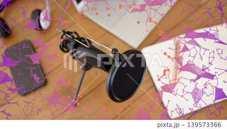Recording black mic with pop filter sitting on tripod at home desk, with laptop and mouse 139573366