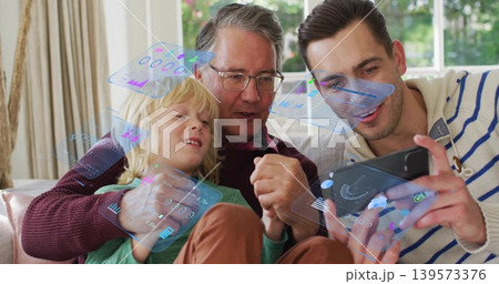 Showing tablet, man tapping holo UI on sofa at home, grandfather wearing glasses and son watching Showing tablet, man tapping holo UI on sofa at home, grandfather wearing glasses and son watching 139573376