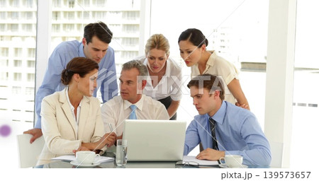 Discussing team reviewing laptop in meeting room with windows, notepad, coffee, in business attire Discussing team reviewing laptop in meeting room with windows, notepad, coffee, in business attire 139573657