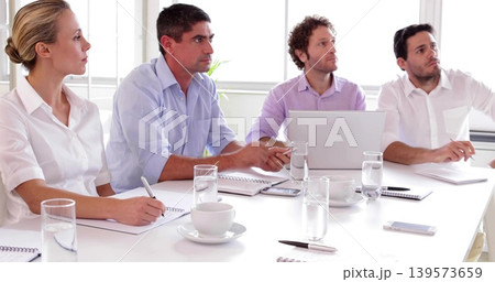 Sitting four colleagues in business casual clothing discussing project in meeting room, with laptop Sitting four colleagues in business casual clothing discussing project in meeting room, with laptop 139573659