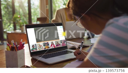Writing child right of table studying with notebook, laptop on call, pencils at home, adult working 139573756