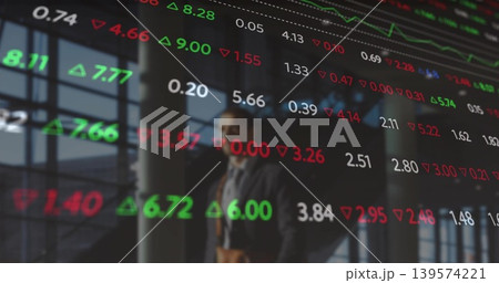 Walking suited businessman through glass atrium, passing digital stock ticker and brown leather bag Walking suited businessman through glass atrium, passing digital stock ticker and brown leather bag 139574221