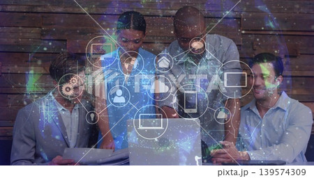 Leaning team in suits pointing at laptop, holding papers and phone at slat wall, overlay Leaning team in suits pointing at laptop, holding papers and phone at slat wall, overlay 139574309
