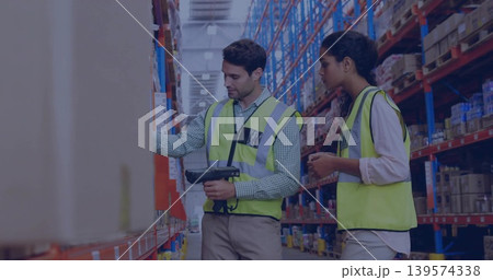 Scanning two warehouse workers checking shelves in aisle, with handheld scanner and high-vis vests Scanning two warehouse workers checking shelves in aisle, with handheld scanner and high-vis vests 139574338