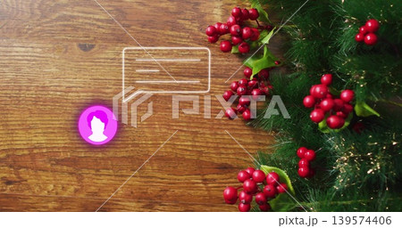 Showing green garland with red berries and tinsel on wood desk, purple avatar chat-icon, copy space Showing green garland with red berries and tinsel on wood desk, purple avatar chat-icon, copy space 139574406