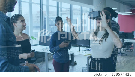 Gesturing female wearing light top and dark skirt using VR headset at open-plan office, copy space 139574426