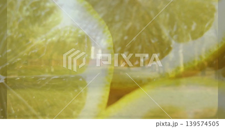 Showing translucent sliced lemons dominating frame at park, revealing membranes, rind, tree path Showing translucent sliced lemons dominating frame at park, revealing membranes, rind, tree path 139574505