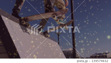 Jumping two skaters in dark, khaki pants, doing aerials at urban skate spot with skateboards, bokeh 139574632