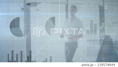 Walking male presenter in business-casual shirt holding coffee cup and remote with charts on glass Walking male presenter in business-casual shirt holding coffee cup and remote with charts on glass 139574644