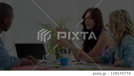 Gesturing woman speaking in meeting room, in sleeveless top, with laptop pen cup papers pencil Gesturing woman speaking in meeting room, in sleeveless top, with laptop pen cup papers pencil 139574774