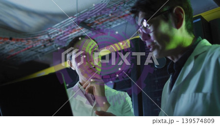 Analyzing two lab scientists examining laptop and hologram in server room, wearing lab coats Analyzing two lab scientists examining laptop and hologram in server room, wearing lab coats 139574809