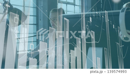Analyzing woman in blouse and blazer viewing candlestick charts at office on screen headset visible Analyzing woman in blouse and blazer viewing candlestick charts at office on screen headset visible 139574993