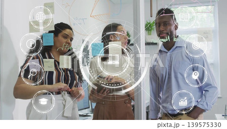Adjusting three-person team in business wear, moving post-its and drawing on glass wall, HUD icons 139575330