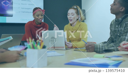 Discussing three staff wearing red, mustard and plaid shirts at meeting table with laptop and slide Discussing three staff wearing red, mustard and plaid shirts at meeting table with laptop and slide 139575410