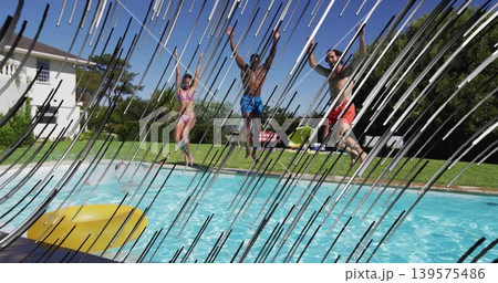 Jumping three friends wearing pink bikini and trunks into backyard pool with yellow inflatable ring Jumping three friends wearing pink bikini and trunks into backyard pool with yellow inflatable ring 139575486