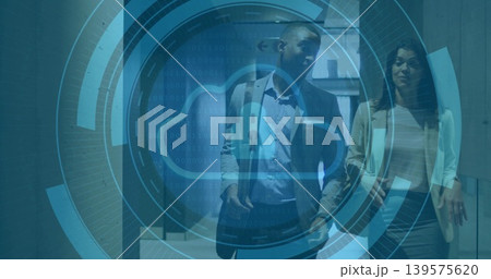 Walking two business pros talking down office corridor in suit and blazer, HUD cloud icon overlay Walking two business pros talking down office corridor in suit and blazer, HUD cloud icon overlay 139575620