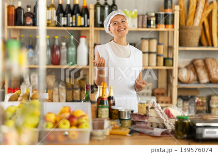 Woman seller with food set in grocery store Woman seller with food set in grocery store 139576074