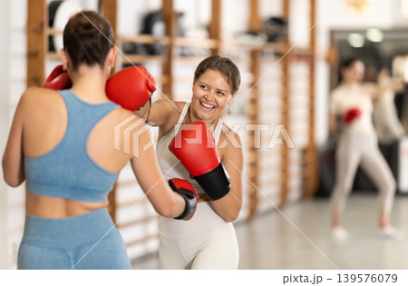Women fight with hands, using all strength, courage during boxing lesson 139576079