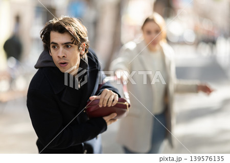 Male thief stealing woman bag on street 139576135