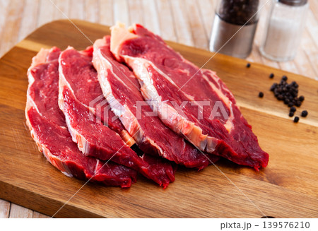 Raw boneless beef with seasonings on wooden background Raw boneless beef with seasonings on wooden background 139576210