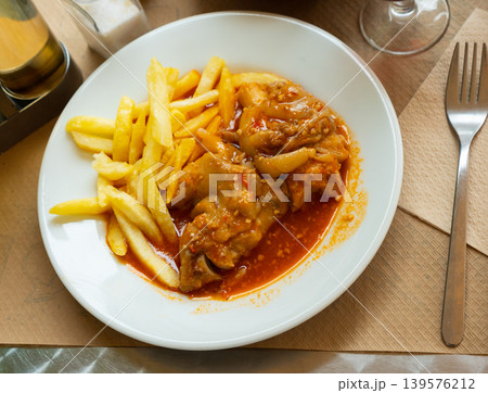 Pork trotters stewed in tomato gravy with fries 139576212
