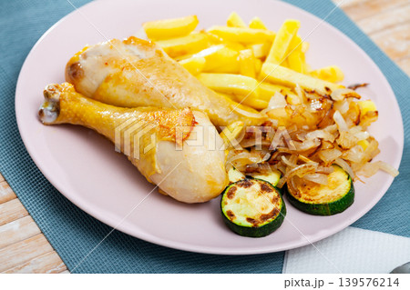 Chicken legs with fried potato and zucchini Chicken legs with fried potato and zucchini 139576214