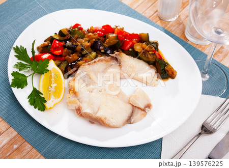 Roasted blue shark steak with vegetable saute, lemon and greens 139576225