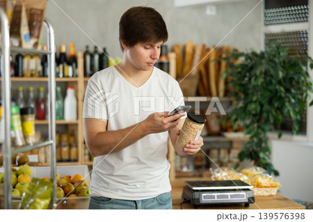 Young man scanning qr code of beans Young man scanning qr code of beans 139576398