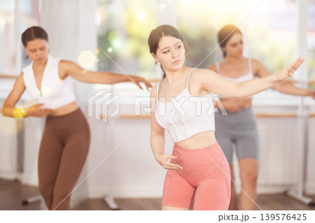 Teenage girl participating in beginner group ballet class Teenage girl participating in beginner group ballet class 139576425