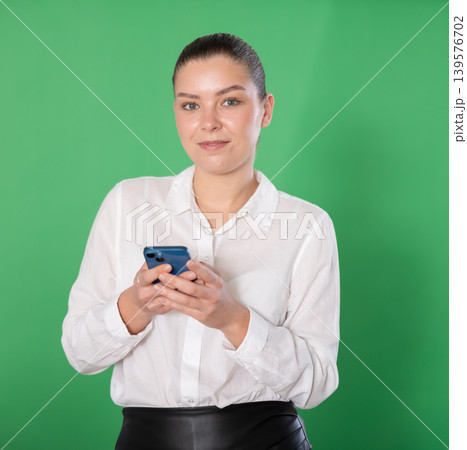 Young girl on green screen background is typing text message Young girl on green screen background is typing text message 139576702