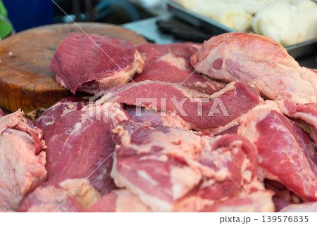 Fresh raw beef cuts displayed on butcher table with natural texture and rich red color for cooking preparation and meat market concept Fresh raw beef cuts displayed on butcher table with natural texture and rich red color for cooking preparation and meat market concept 139576835