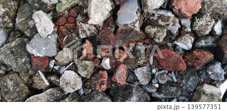 Close-up shot of a pile of broken concrete, stone, and red brick with rough texture and contrasting natural colors. Close-up shot of a pile of broken concrete, stone, and red brick with rough texture and contrasting natural colors. 139577351